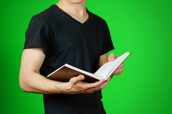 Närbild av killen i svart t-shirt håller tomt öppen vit bok — Stockfoto