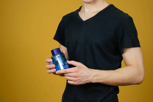 Hombre en camiseta negra sosteniendo la botella azul de agua del inodoro. De cerca. , —  Fotos de Stock