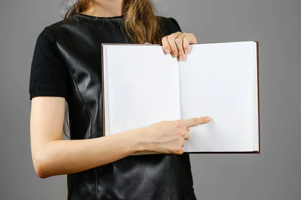 Closeup of girl in black dress holding blank open white book on — Stock Photo, Image