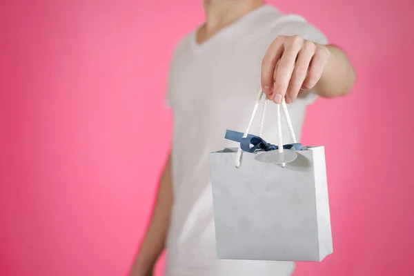 Hombre sosteniendo en la mano en blanco bolsa de regalo de papel azul se burlan. Vacío pac —  Fotos de Stock