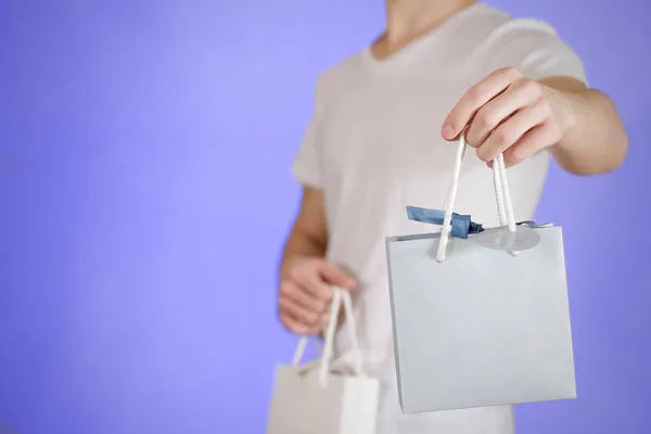 Hombre sosteniendo en la mano en blanco dos bolsa de regalo de papel se burlan. Envase vacío —  Fotos de Stock