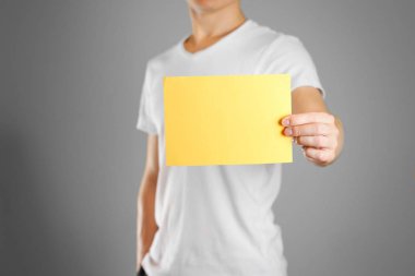 Bir adam sarı bir kağıt elinde tutuyor. Boş bir el ilanı gösterir. ISO