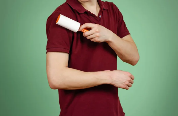 Un hombre limpia el rodillo pegajoso de la camiseta. Primer plano. Aislado —  Fotos de Stock