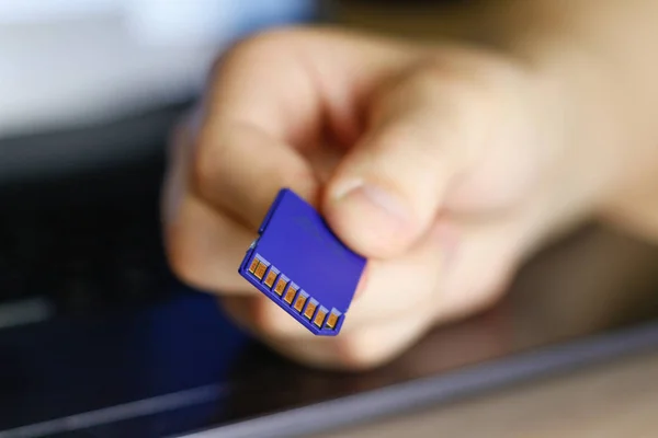 Hand håller SD-minneskort. Blå. — Stockfoto
