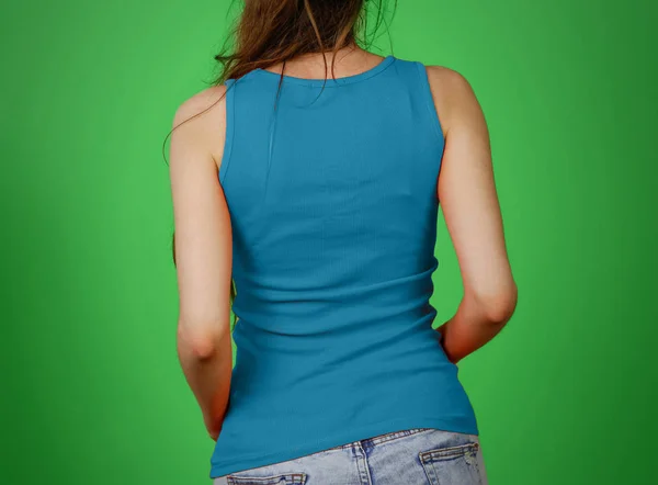 Uma rapariga com uma t-shirt azul. Parte superior vazia do tanque. Fecha a porta. Isolar — Fotografia de Stock