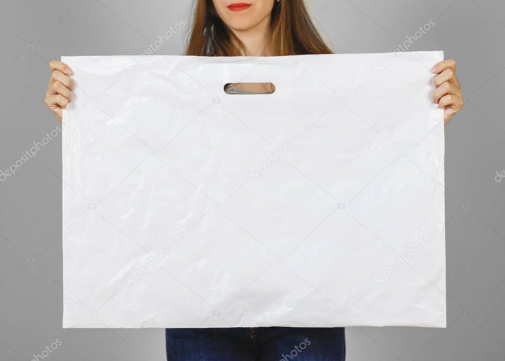 Girl holds a white plastic bag. Closeup. Isolated