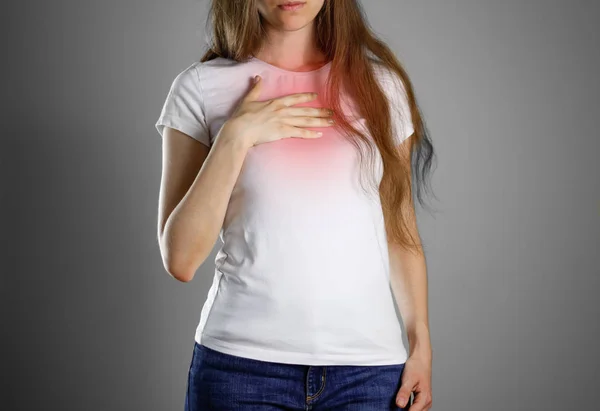 A woman holds the Breasts. The pain in her chest. Heartburn. Sto — Stock Photo, Image