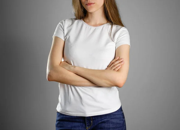 Mulher de t-shirt branca em branco. A menina dobrou as mãos em seu c — Fotografia de Stock