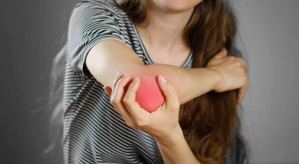 The girl has a sore elbow. The pain in my arm. Closeup. The lesi — Stock Photo, Image