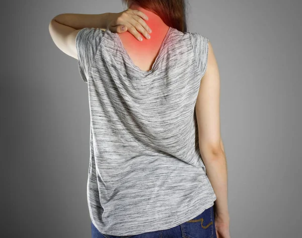 La chica de camiseta gris se aferra a la parte posterior de la cabeza. Dolor en — Foto de Stock