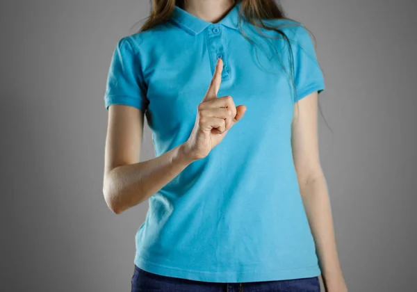 위쪽에 파란 t-셔츠 가리키는 손가락에 여자. 지정 일 — 스톡 사진