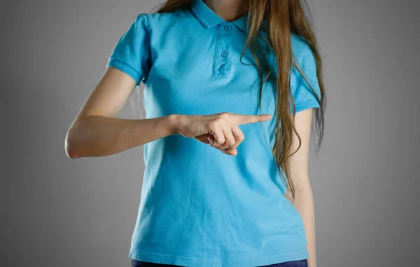 La ragazza con la maglietta blu che punta il dito a destra. Specifica — Foto Stock