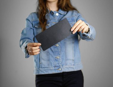 Kız mavi kot gömlek siyah boş parçası tutar 