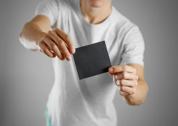 Чоловік у сірій футболці тримає порожній прозорий чорний лист . — стокове фото