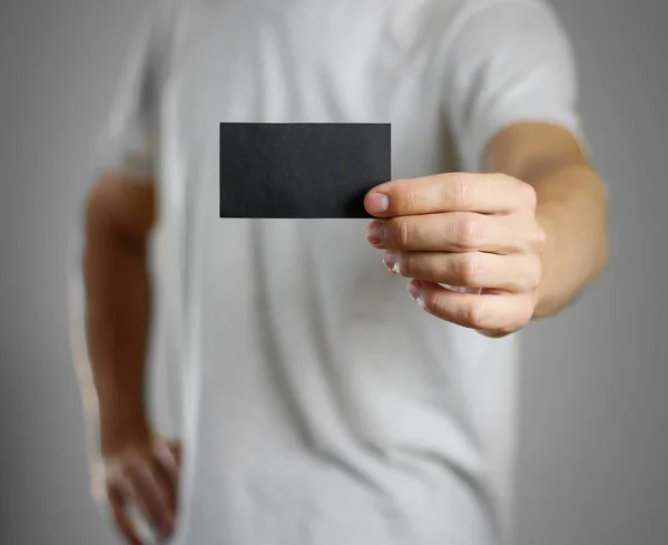 Muž v šedivé triko drží prázdné clear black listu. — Stock fotografie