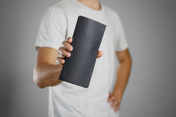 Мужчина в серой футболке, держащий чистый черный лист простыни . — стоковое фото