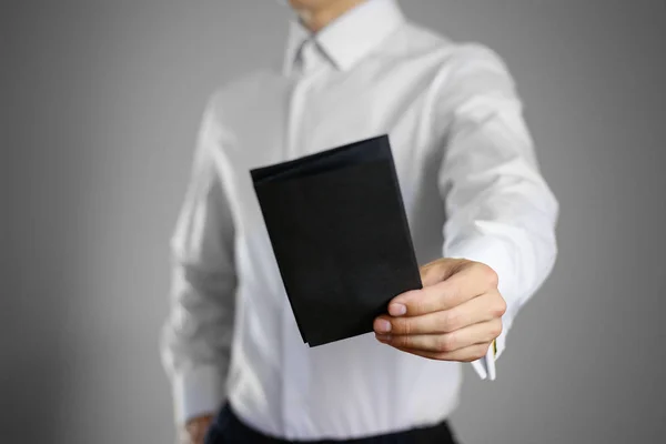 Číšník v bílé košili drží prázdné transparentní černá ta — Stock fotografie