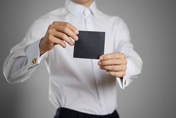 Číšník v bílé košili drží prázdné transparentní černá ta — Stock fotografie