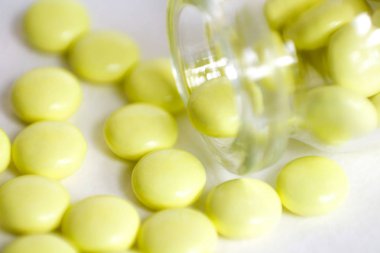 Sarı haplar şişe dağınık. Makro. Portre. Isolat