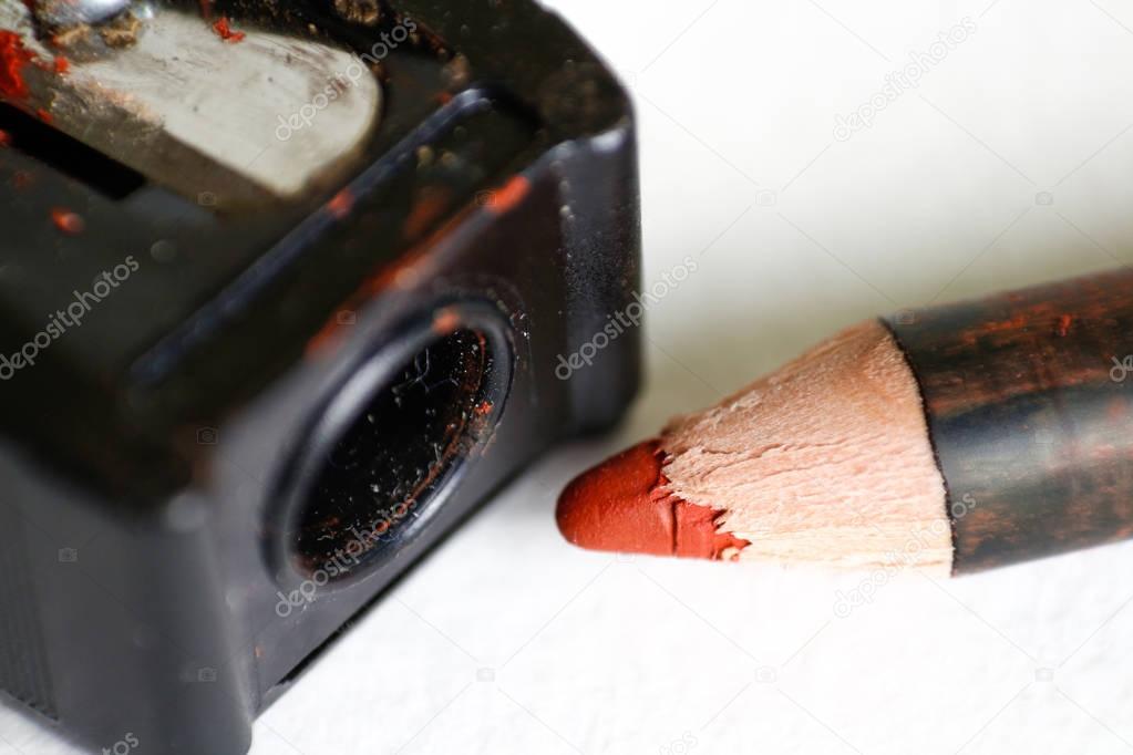 Red pencil for makeup and sharpener. Macro. Closeup. Isolated on