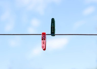 İp üzerinde yeşil ve kırmızı clothespins dönüştürün. Mavi arka plan üzerinde