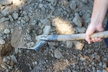 Erkek el bir kürekle kazmaya. Kürek toprak. Closeu