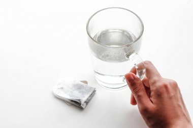 Elini tut şeffaf cam kupa ve bir çay poşeti. Bir fincan çay. ISO