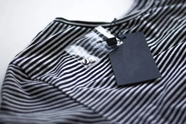 Etiqueta negra con el tamaño y precio de la camiseta. Primer plano. — Foto de Stock