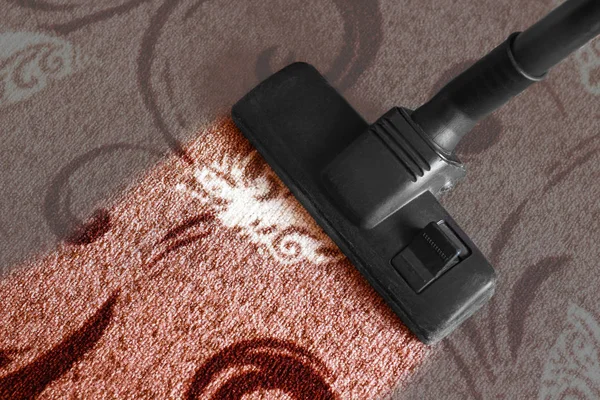 La aspiradora de fregona limpia alfombras en el suelo de la sala de