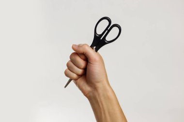 Erkek holding siyah makas eller. Gri arka plan üzerinde izole. 