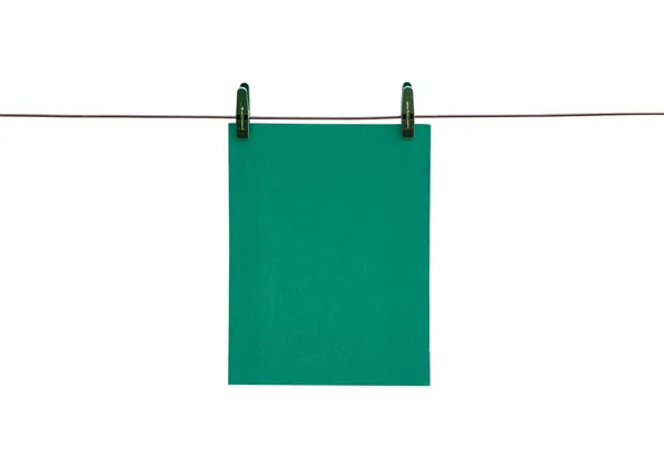 Den gröna pappersark hänger på linan med klädnypor. Stäng — Stockfoto
