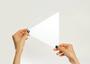 Bir beyaz üçgen parça kağıt tutan eller. İzole