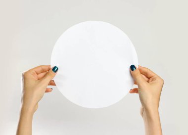 Bir beyaz yuvarlak kağıt parçası tutan eller. G izole