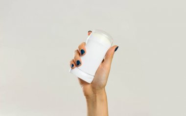 Beyaz deodorant tutan eller. Üzerinde gri adam izole