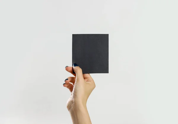 Руки женщины держат черный лист бумаги. Изолированный на заднем плане — стоковое фото
