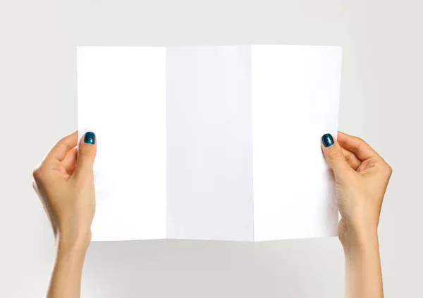 Mains féminines tenant un livret blanc triple feuille de papier. Isol — Photo