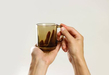 Siyah boş bardak kupa tutan erkek el. Üzerinde gri backgr izole