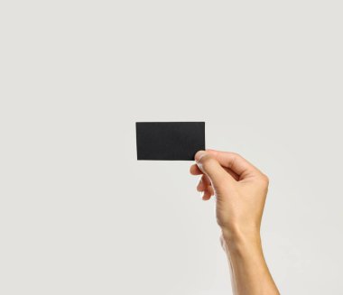 Erkek siyah parça kağıt tutan eller. Gri arkasında izole