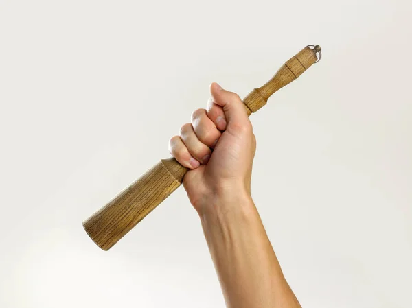 Mãos masculinas segurando um pilão de madeira. Isolado em fundo cinza . — Fotografia de Stock