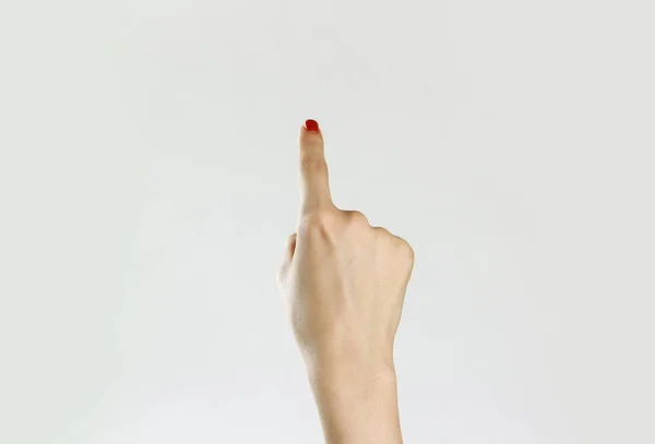 Vrouwelijke hand geeft de richting. Geïsoleerd op een grijze achtergrond. Cl — Stockfoto