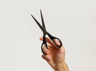 Erkek holding siyah makas eller. Gri arka plan üzerinde izole. 