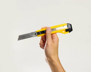 Erkek sarı keskin maket tutan eller. Üzerinde gri bac izole