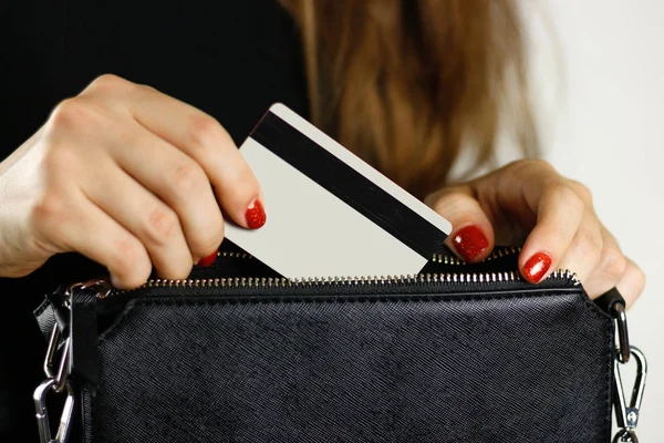 Siyah elbiseli kız siyah bir çanta kredi kartından ortaya çıkarır. CL