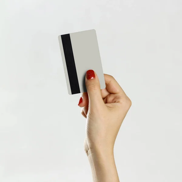 Mano femenina con tarjeta de crédito. Aislado sobre fondo gris. Cl — Foto de Stock