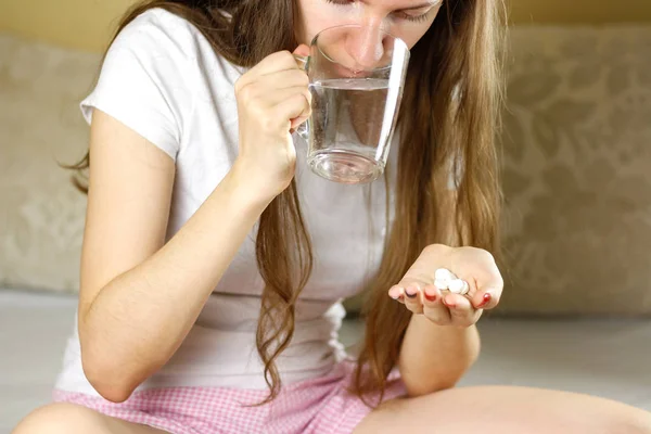 Dívka drží sklenici vody a prášky. Closeup — Stock fotografie