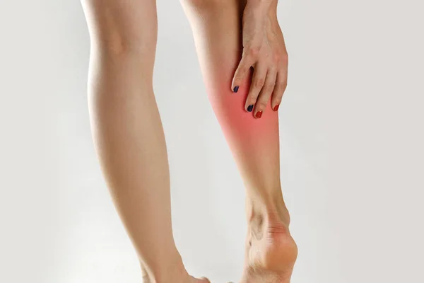 The girl has a pain in his leg. Holding his hands behind his leg — Stock Image The girl has a pain in his leg. Holding his hands behind his leg Stock Image