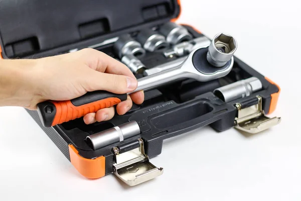 A mão segurando a ferramenta. Kit de ferramentas para o carro. Isolados em que — Fotografia de Stock