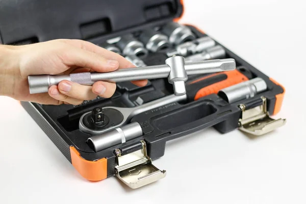 A mão segurando a ferramenta. Kit de ferramentas para o carro. Isolados em que — Fotografia de Stock