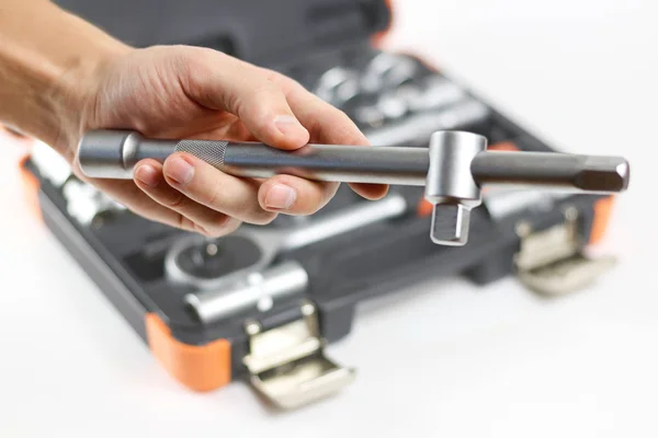 The hand holding the tool. Tool kit for the car. Isolated on whi — Stock Photo, Image