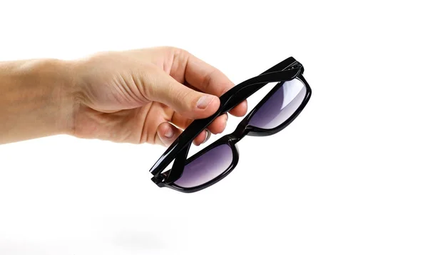 Χέρι κρατά μαύρα γυαλιά ηλίου. Απομονωμένα σε λευκό φόντο — Φωτογραφία Αρχείου